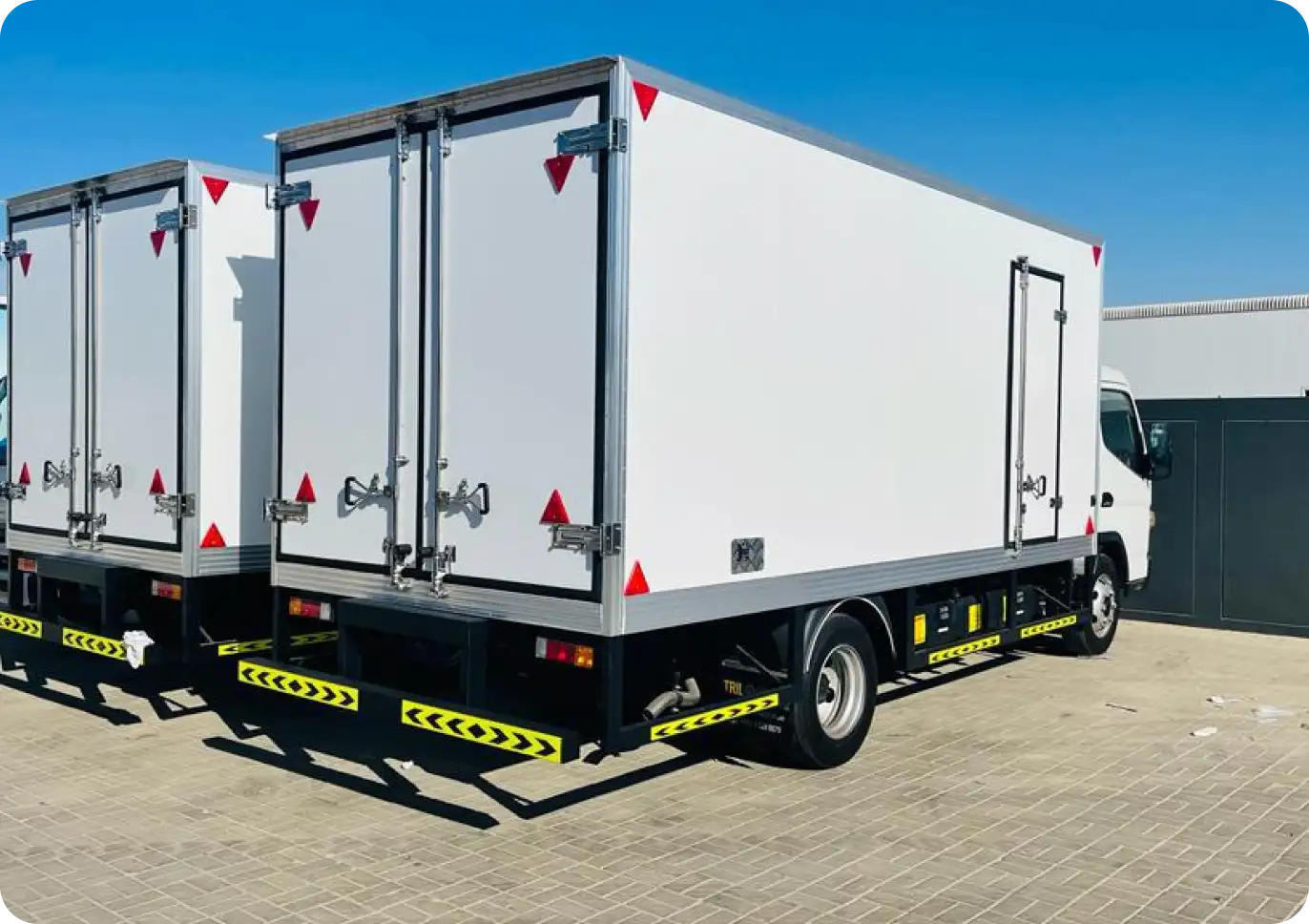 Chiller truck parked at an event venue in Abu Dhabi with catering staff loading fresh food trays into the refrigerated compartment