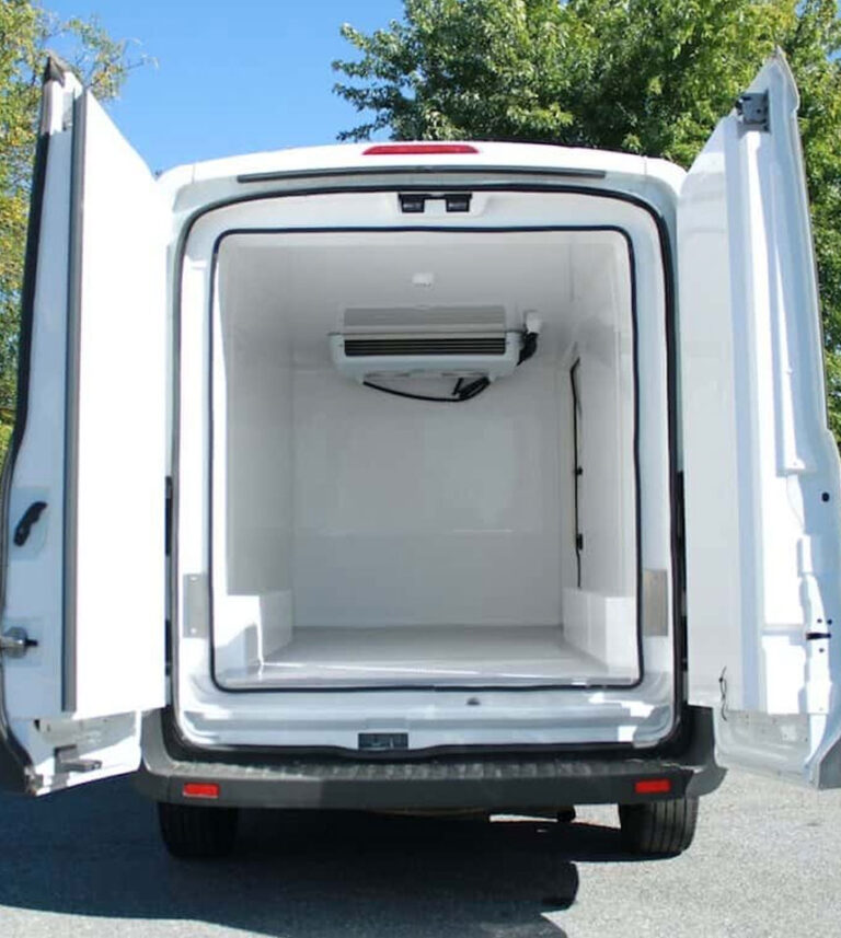 A modern white chiller van parked in an Abu Dhabi commercial zone